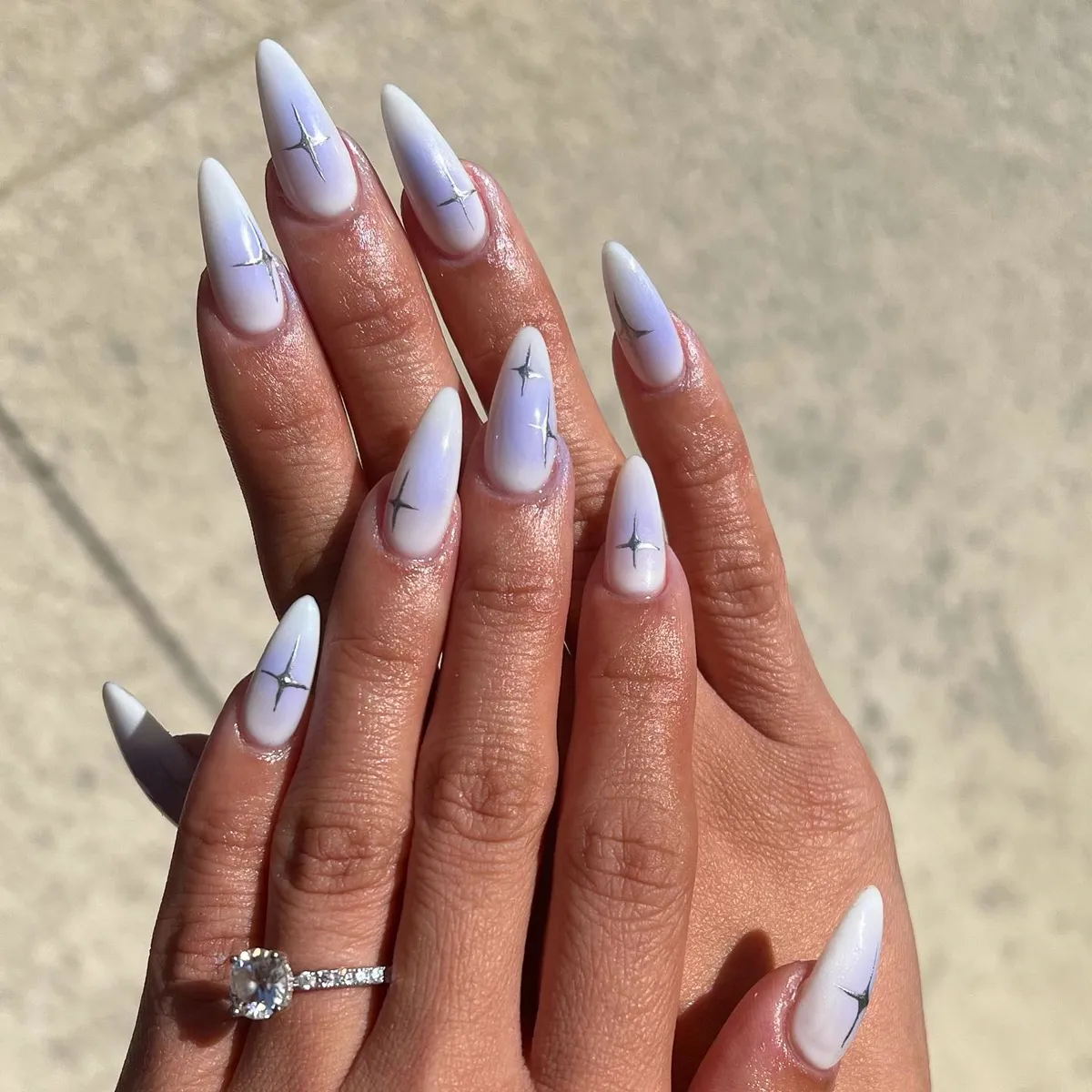 Long almond nails in a soft lilac and white marble finish