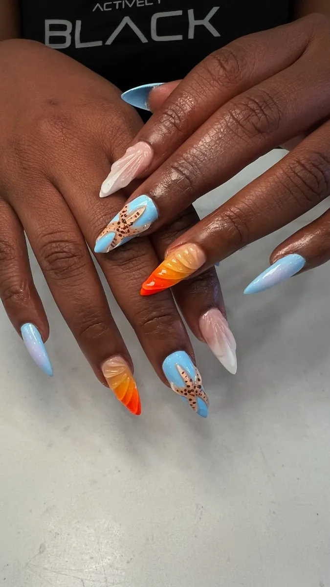 Long almond nails in sky blue with orange flame and gold charm accents