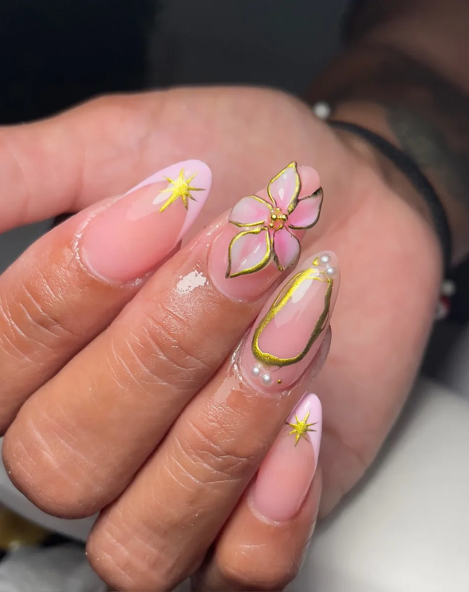 Pink French almond nails with gold outlined flower and star art
