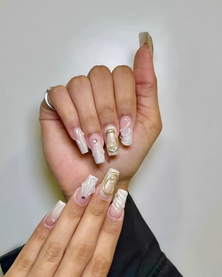 Short nails with white micro French tips and small gold accents