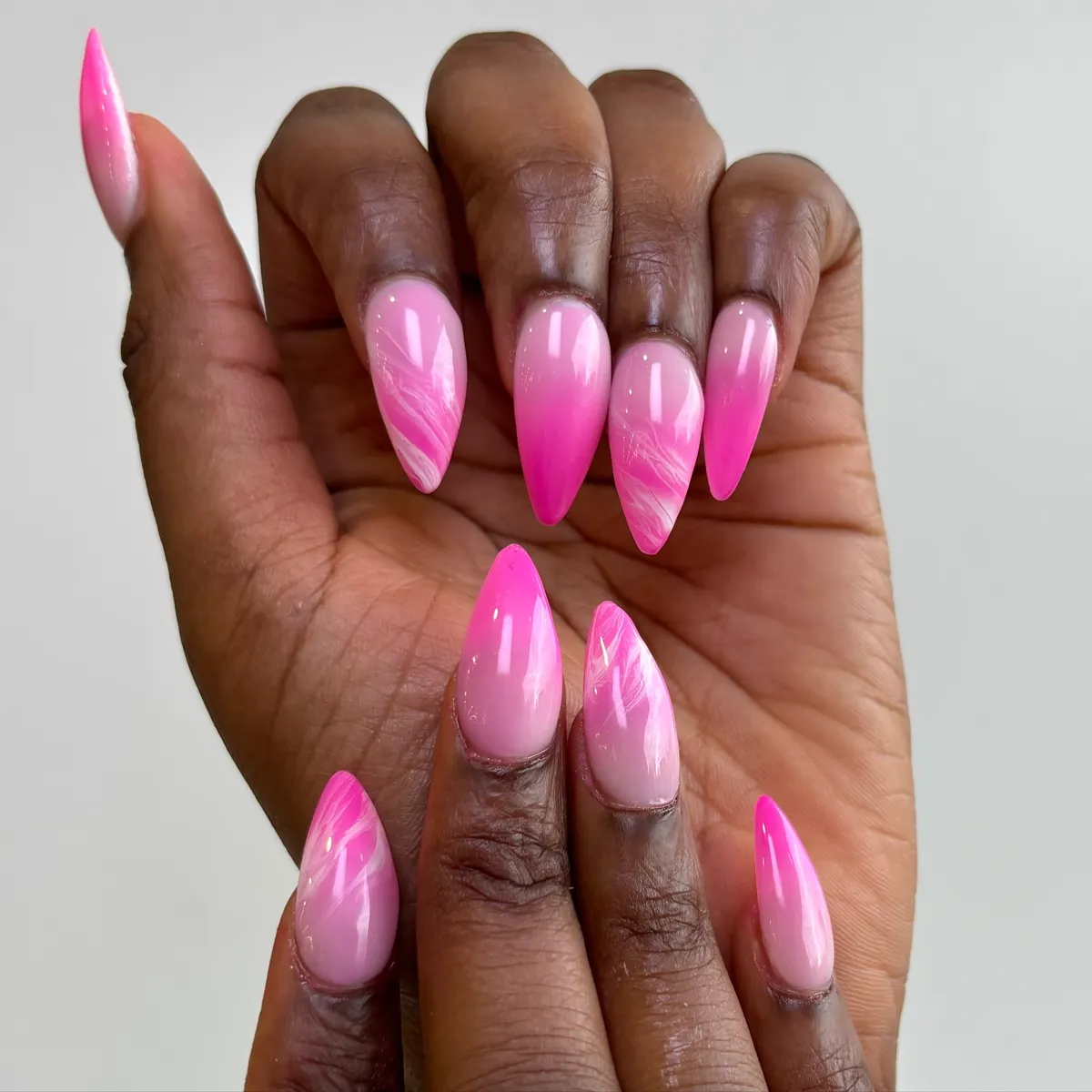 Almond nails in glossy hot pink with a swirled two-tone design