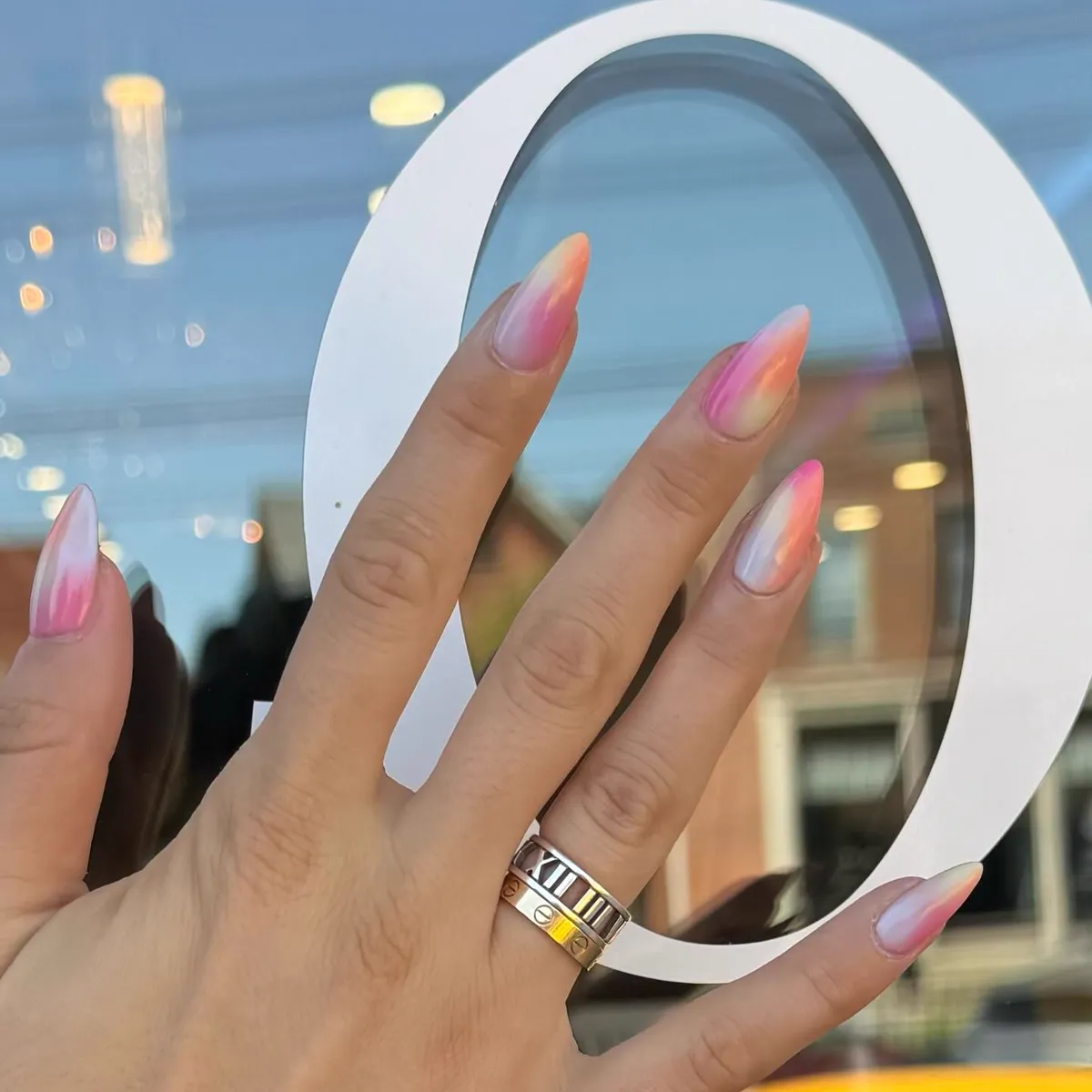 Sheer peach and pink ombre almond nails with a glass finish